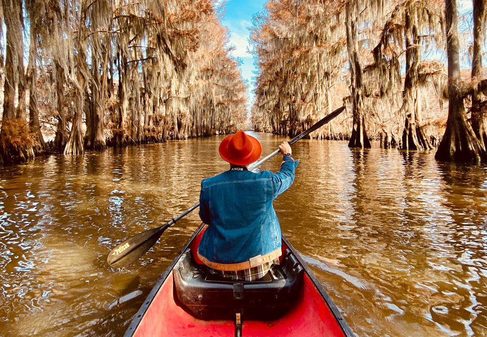 Dude kayaking on a lake experiencing the benefits of adventure