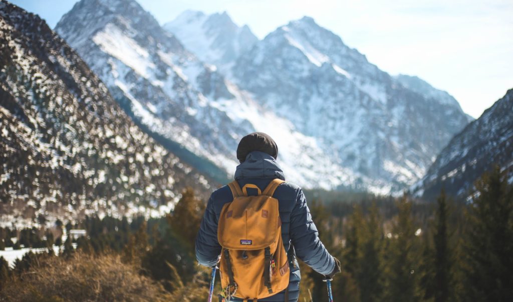 men s blue leather jacket and brown backpack